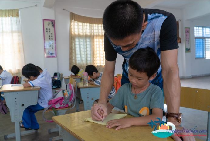 A teacher in Hainan helping one of his students in Beigang elementary school