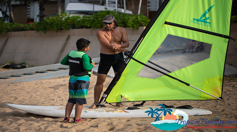 Things to do in Haikou man teaching boy how to windsurf