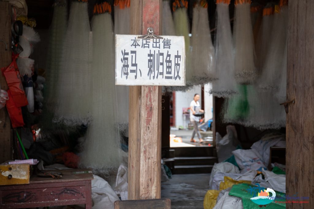 A photo of fishing nets hanging up at a fish market. 