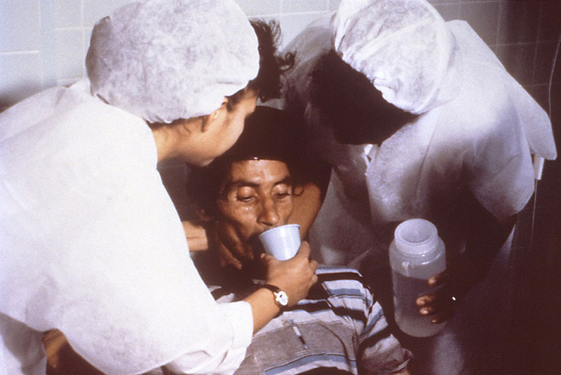 This cholera patient is drinking oral rehydration solution (ORS) in order to counteract his cholera-induced dehydration
