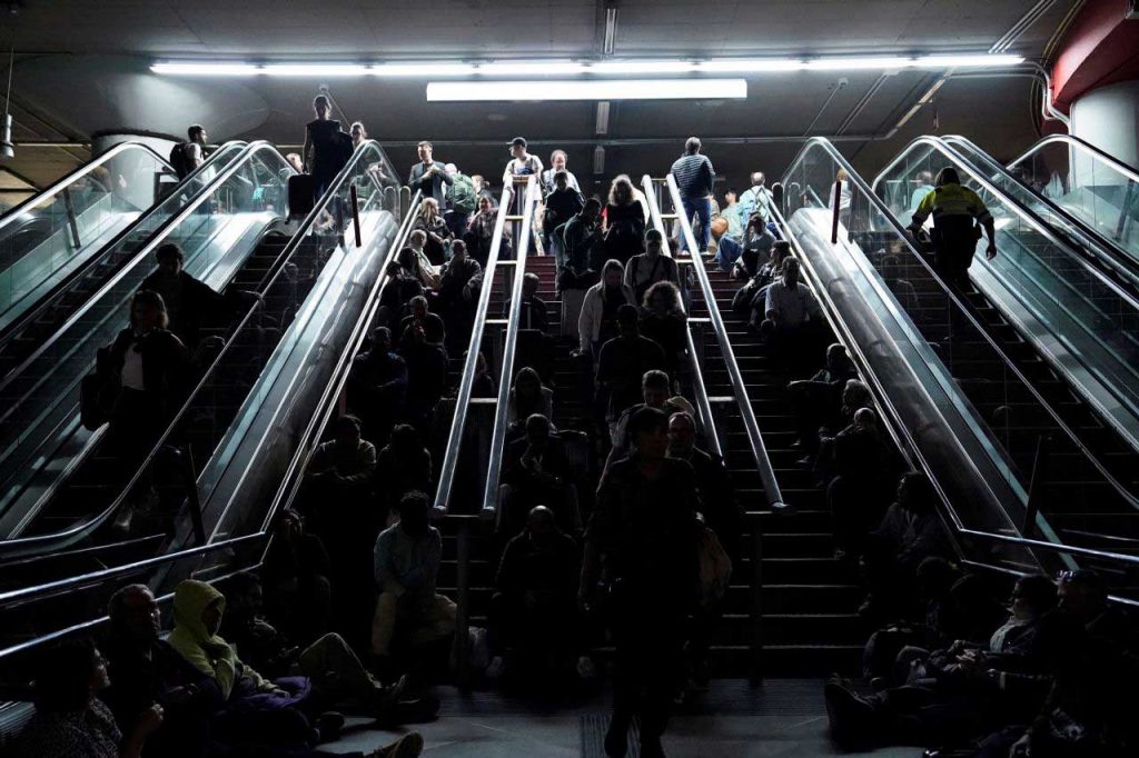 People rest on the stairs at Atocha train station in Madrid during Europes worst grid failure in history